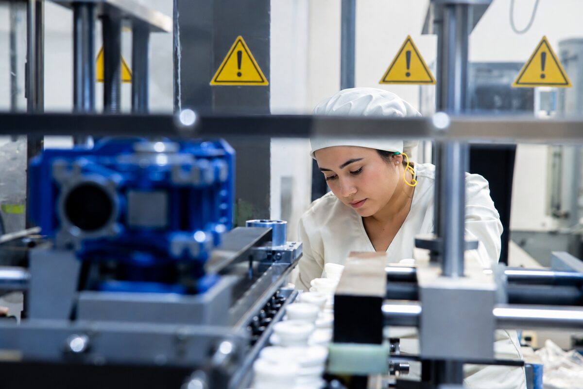 Operaria revisando envases en la línea de producción