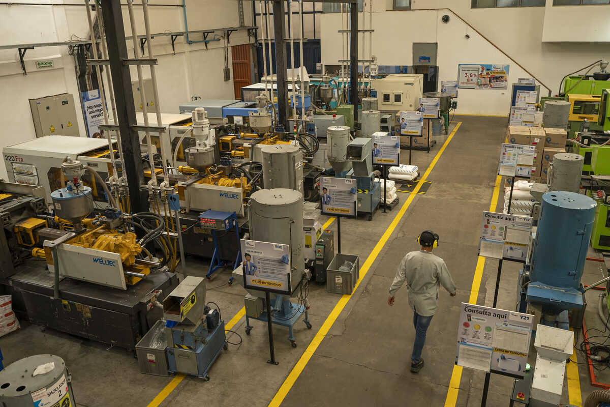 Operario caminando entre las líneas de producción
